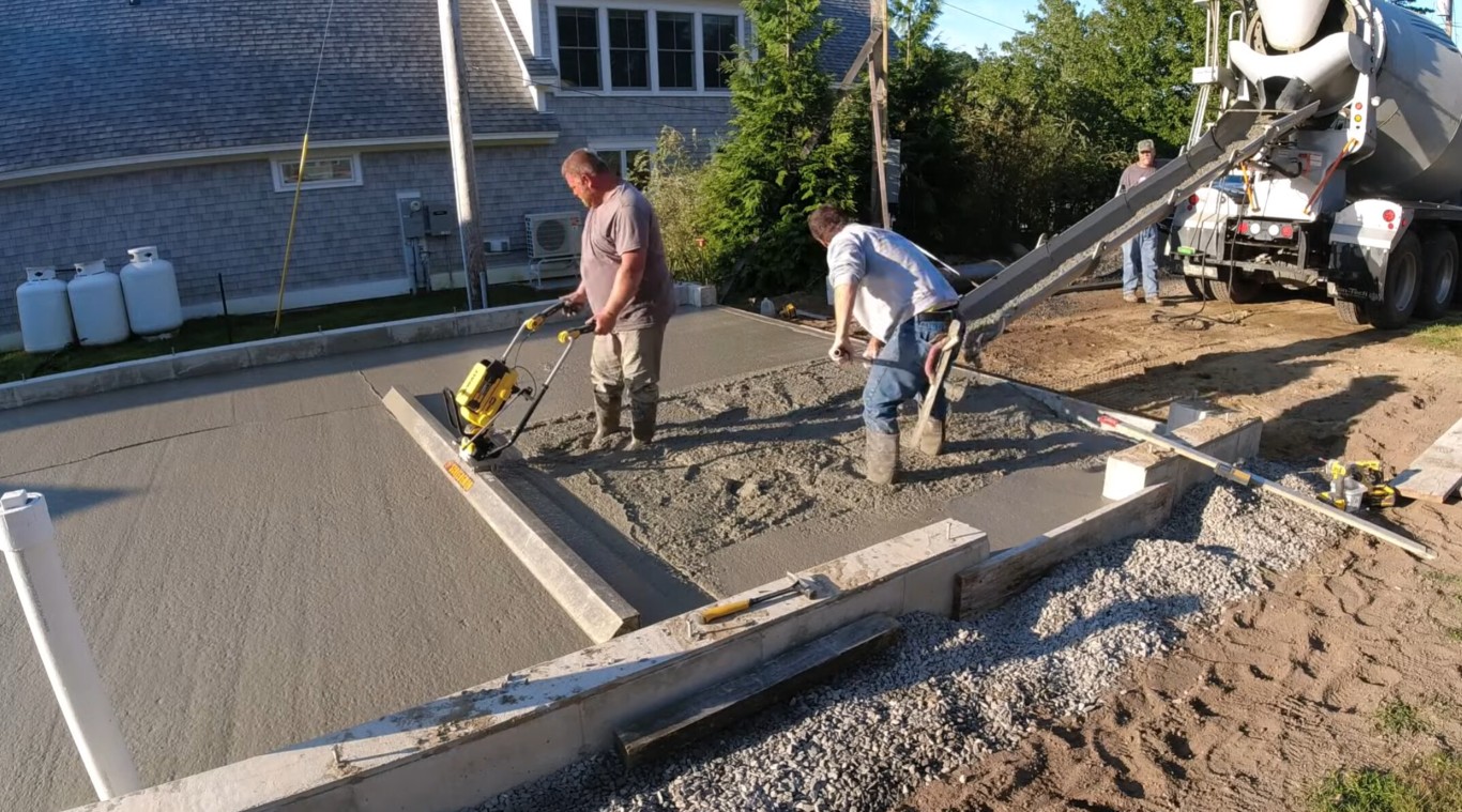 Professional concrete workers pouring driveway in Chino, CA